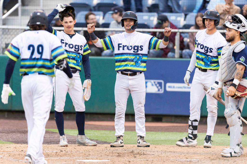 Austin St. Laurent, Anthony Donofrio and Jonny Farmelo celebrate Carter Dorighi as he crosses home plate after hitting a home run during the game against the Hillsboro Hops on Wednesday, May 6, 2026 in Everett, Washington. (Olivia Vanni / The Herald)
