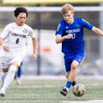 Shorewoods Julian Shook takes the ball up the field while under pressure from Lynnwoods Kai OBrien during the 3A district semifinal game on Tuesday, May 12, 2026 in Shoreline, Washington. (Olivia Vanni / The Herald)