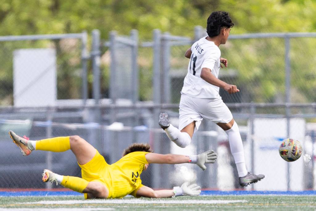 Lynnwoods Henrry Torres-Hernandez jumps over Shorewoods Maxwell Smith during the 3A district semifinal game on Tuesday, May 12, 2026 in Shoreline, Washington. (Olivia Vanni / The Herald)
