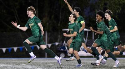 Shorecrests Kai Short and teammates run toward Shorecrests Maceo Jala after he scores the winning penalty kick to beat Edmonds-Woodway in the 3A district semifinal game on Tuesday, May 12, 2026 in Shoreline, Washington. (Olivia Vanni / The Herald)