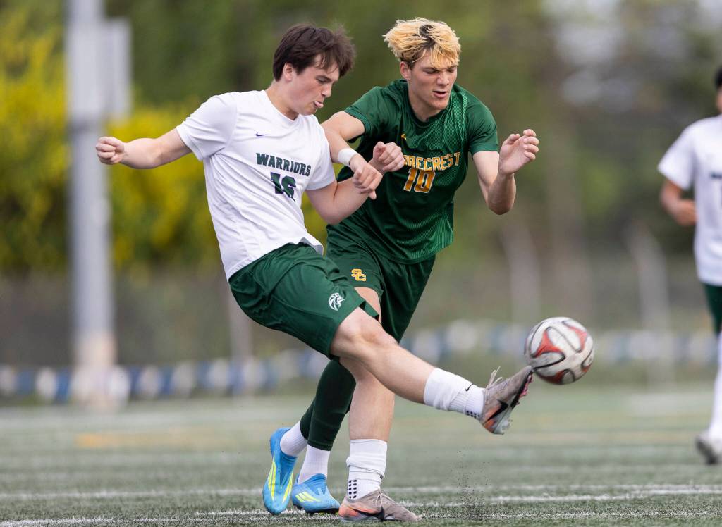 Edmonds-Woodways Campbell Turcott crosses the ball while under pressure from Shorecrests Cole Ambrose during the 3A district semifinal game on Tuesday, May 12, 2026 in Shoreline, Washington. (Olivia Vanni / The Herald)