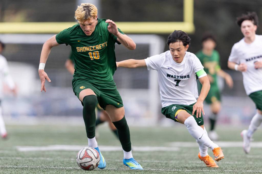 Shorecrests Cole Ambrose dribbles the ball up the field while under pressure from Edmonds-Woodways Benjamin Ikegami during the 3A district semifinal game on Tuesday, May 12, 2026 in Shoreline, Washington. (Olivia Vanni / The Herald)