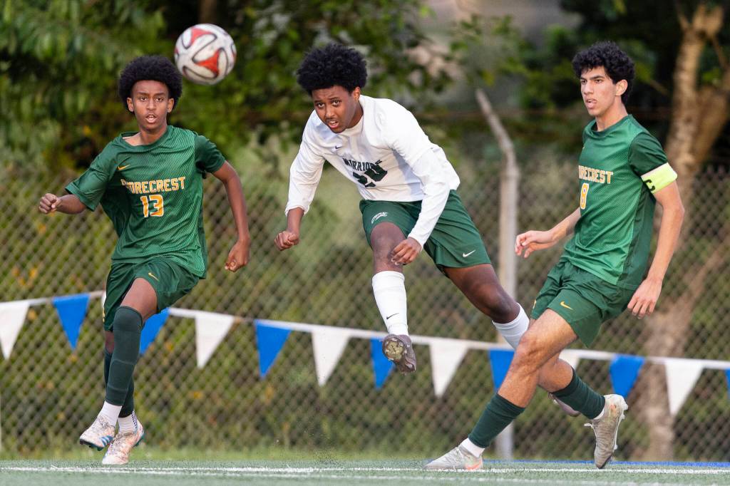 Edmonds-Woodways Neaphtali Daniel crosses the ball while under pressure from Shorecrests Nani Dereje and Ameen Tirhi during the 3A district semifinal game on Tuesday, May 12, 2026 in Shoreline, Washington. (Olivia Vanni / The Herald)