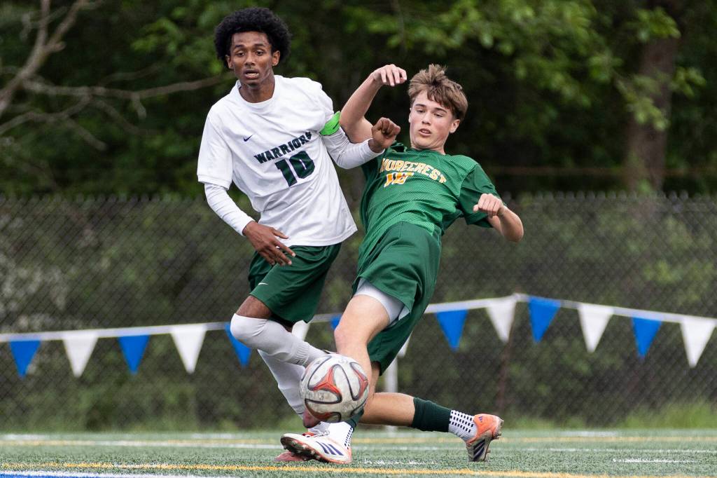 Shorecrests Drew Mathieson crosses the ball while under pressure from Edmonds-Woodways Natan Ghebreamlak during the 3A district semifinal game on Tuesday, May 12, 2026 in Shoreline, Washington. (Olivia Vanni / The Herald)