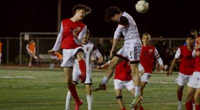 Snohomish junior Paul Joplin (left) heads the ball past a jumping Monroe defender in the Panthers 4-1 loss at Veterans Memorial Stadium in Snohomish, Washington on April 4, 2025. (Joe Pohoryles / The Herald)