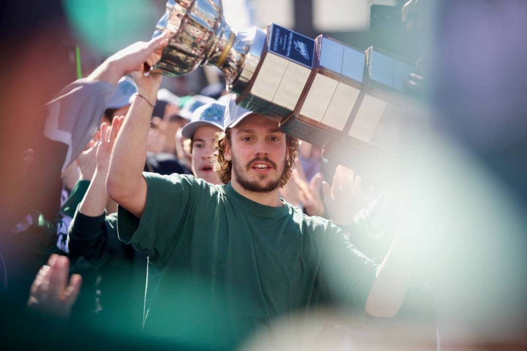 Silvertips forward Rylan Gould carries the Ed Chynoweth Cup through a crowd of fans in front of Everett High School on May 16, 2026 upon the teams return from its WHL Championship-clinching win against the Prince Albert Raiders the night before. (Joe Pohoryles / The Herald)