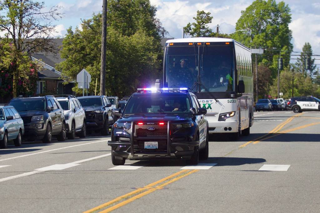 Receiving a police escort, the Everett Silvertips team bus arrives at Everett High School on May 16, 2026. (Joe Pohoryles / The Herald)