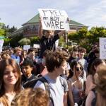 Shea Caross holds a sign in support of keeping Bothell High Schools school resource officer Officer Ware during a walkout in protest of the school boards vote to not renew the contract for his position at the school on Monday, May 18, 2026, in Bothell, Washington. (Olivia Vanni / The Herald)