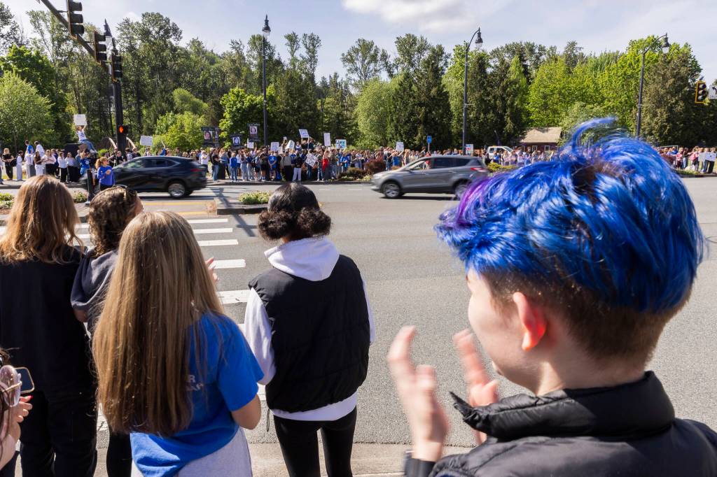 More than 200 students and community members line Bothell Way in protest of the school boards vote to not renew the contract for Bothell High Schools school resource officer on Monday, May 18, 2026, in Bothell, Washington. (Olivia Vanni / The Herald)