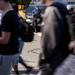 Bothell High Schools school resource officer Garrett Ware watches as students walk out of the high school in protest of the school boards vote to not renew the contract for his position at the school on Monday, May 18, 2026, in Bothell, Washington. (Olivia Vanni / The Herald)