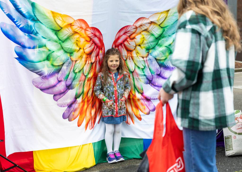 Olivia Vanni / The Herald
Evelyn Freedman, 5, poses for a picture in front of rainbow wings for her mom Hailey Freedman during the Everett Pride Block Party on June 21, 2025 in Everett, Washington.