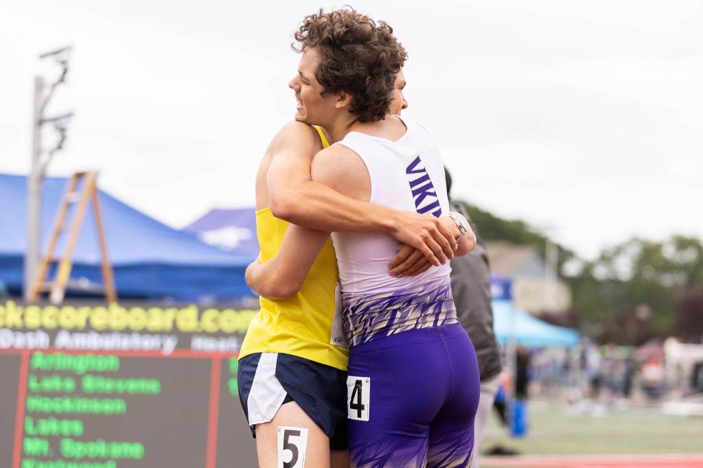 Arlingtons Ramon Little, left, and Lake Stevens Avery Couchette embrace after racing in the boys ambulatory 400 M final during the WIAA State Track & Field Championships on Friday, May 29, 2026 in Tacoma, Washington. (Olivia Vanni / The Herald)