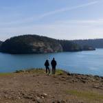 People stand at the edge of Rosario Head at Deception Pass State Park and look out toward Northwest Pass on Monday, March 2, 2026 in Anacortes, Washington. (Olivia Vanni / The Herald)