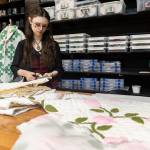 Matti Birdsong cuts a thrifted quilt to be made into a robe at FauxyFurr Vintage + Handmade on Tuesday, June 2, 2026 in Arlington, Washington. (Olivia Vanni / The Herald)