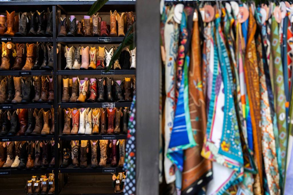 Boots line an entire wall inside FauxyFurr Vintage + Handmade on Wednesday, May 27, 2026 in Arlington, Washington. (Olivia Vanni / The Herald)