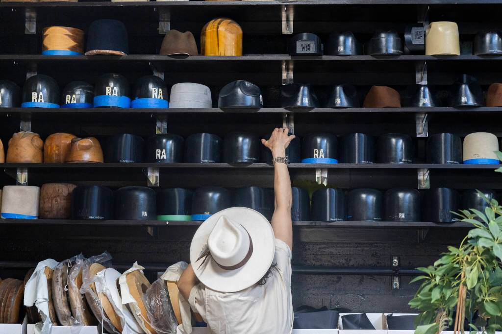 Jac Cash reaches for a hot mold at FauxyFurr Vintage + Handmade on Tuesday, June 2, 2026 in Arlington, Washington. (Olivia Vanni / The Herald)