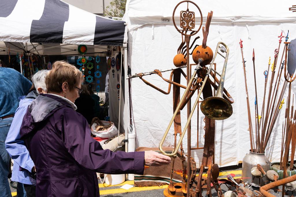 Shoppers look at artwork during the Sorticulture gardening festival on Friday, June 5, 2026 in downtown Everett, Washington. (Will Geschke / The Herald)
