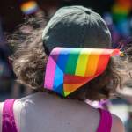 A person wears a pride flag in their hat during the second annual Arlington Pride at Legion memorial Park in Arlington in 2023. (Annie Barker / The Herald file photo)