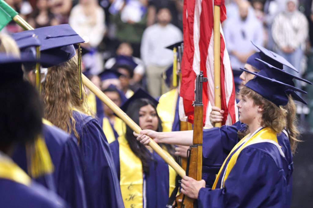 Malachi Smith, right, presents the colors along with other members of the Navy Junior Reserve Officers Training Corps Honor Guard during commencement for Everett High School at the Angel of the Winds Arena on Saturday, June 13, 2026, in Everett, Washington. (Michael Hennneke / The Herald)