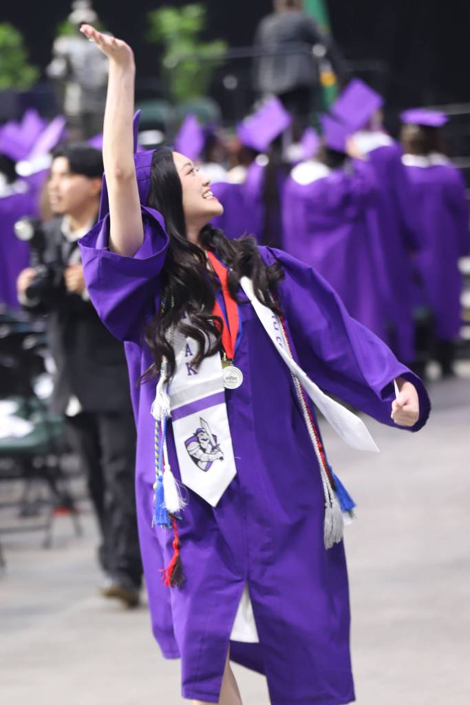 A Kamiak High School graduate responds to members in the crowd during the processional at Kamiak High School commencement at the Angel of the Winds Arena on Friday, June 12, 2026, in Everett, Washington. (Michael Hennneke / The Herald)