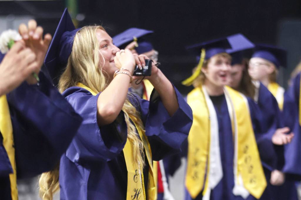 An Everett High School graduate acknowledges well-wishers in the crowd during the processional at Everett High School commencement at the Angel of the Winds Arena on Saturday, June 13, 2026, in Everett, Washington. (Michael Hennneke / The Herald)