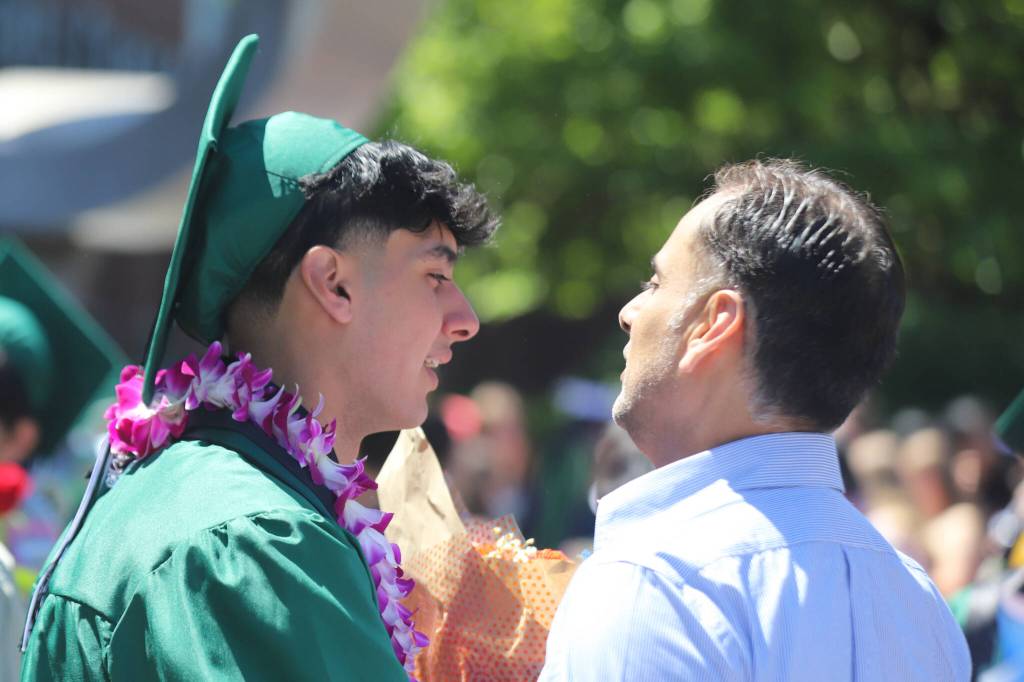 A graduate from Henry M. Jackson High School shares a moment with a well-wisher after commencement at the Angel of the Winds Arena on Saturday in Everett. (Michael Hennneke / The Herald)