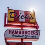 Two seagulls sit on top of the Dicks sign in Edmonds. (Olivia Vanni / The Herald)