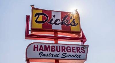 Two seagulls sit on top of the Dicks sign in Edmonds. (Olivia Vanni / The Herald)