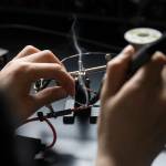 Ashley Lin solders a pair of wires together for their ROV on Wednesday, June 3, 2026 in Edmonds, Washington. (Olivia Vanni / The Herald)