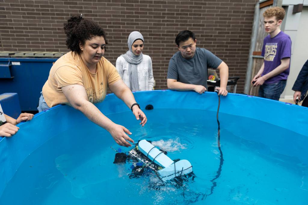 Shere Beshay places the teams ROV, named Razorbill, into a small pool for testing on Wednesday, June 3, 2026 in Edmonds, Washington. (Olivia Vanni / The Herald)