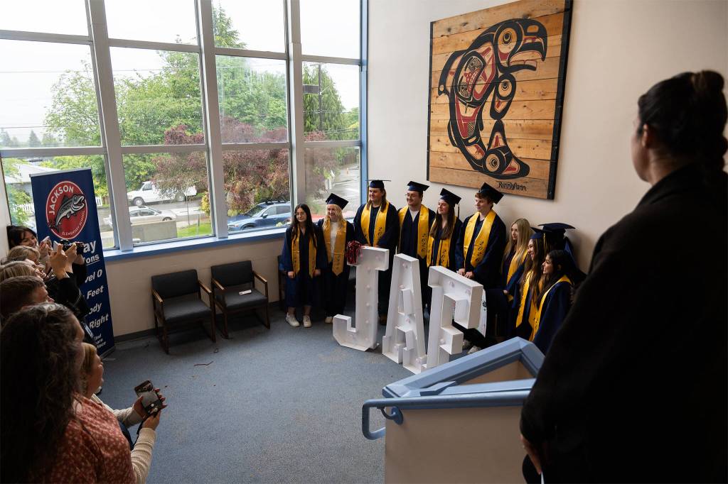 District staff and family members get photos of the graduating Everett High School students after the grad walk ceremony at Jackson Elementary School on Tuesday, June 9, 2026, in Everett, Washington. (Will Geschke / The Herald)