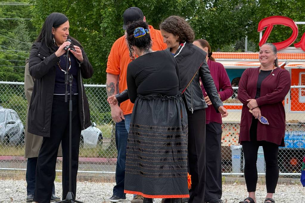 A member of the Tulalip Tribes wraps a blanket around Jasmine Donovan, the president and CEO of Dicks Drive-In Restaurants, to symbolize love, partnership and long-term success Monday in Tulalip. (Jenna Millikan / The Herald)
