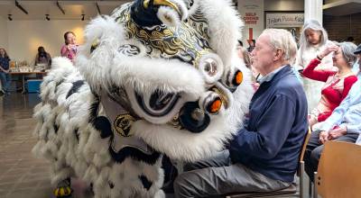 A lion dancer from the Mak Fai Kung Fu Club interacts with an audience member during World Refugee Day at Edmonds Colleges Brier Hall on Friday, June 12, 2026, in Edmonds, Washington. World Refugee Day was first celebrated in 2001 to celebrate the 50th anniversary of the United Nations 1951 Refugee Convention, which internationally recognized refugees and outlined their legal rights. (Michael Hennneke / The Herald)