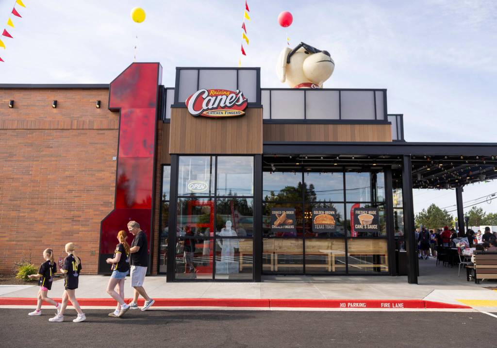 People walk through the parking lot of the new Raising Canes on Tuesday, June 23, 2026 in Lynnwood, Washington. (Olivia Vanni / The Herald)