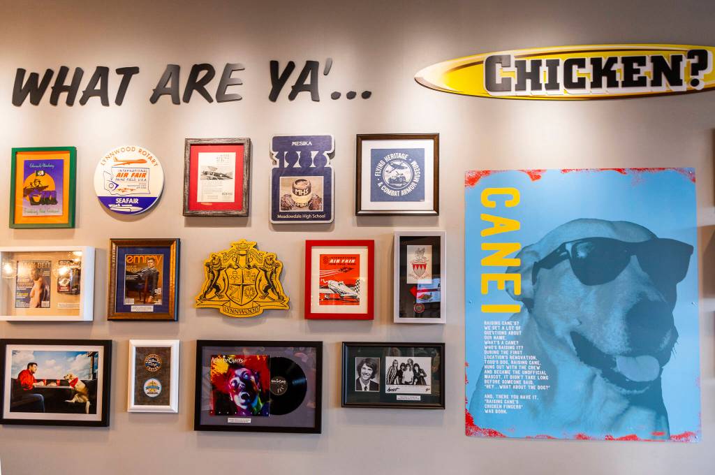 A wall is covered in Lynnwood and Raising Canes themed items and art on Tuesday, June 23, 2026 in Lynnwood, Washington. (Olivia Vanni / The Herald)