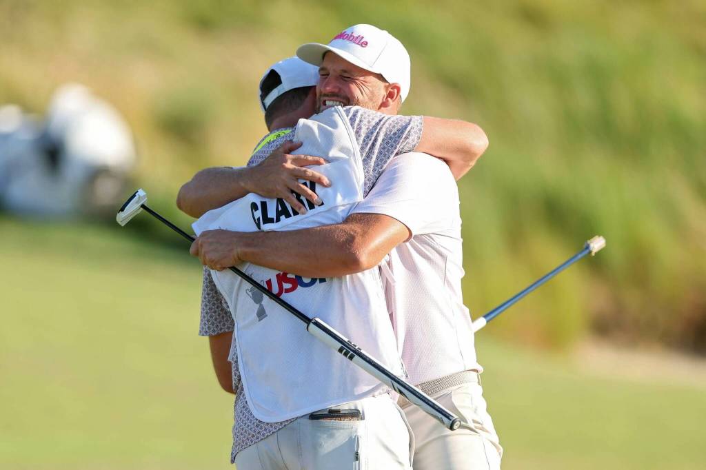 Wyndham Clark celebrates with his caddie, David Pelekoudas, on the 18th green during the final round of 126th U.S. Open Championship at Shinnecock Hills Golf Club on Sunday in Southampton, New York. (Getty Images / The Athletic)