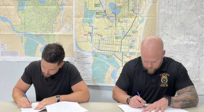 Snohomish Mayor Aaron Hoffman, left, and Teamsters Local 763 Secretary-Treasurer Chad Baker sign new collective bargaining agreements. (Provided photo)