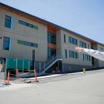 Everett Public Schools Senior Construction Manager Steven Krause, talks about the plan for the old school building next to the finished exterior of the new Jackson Elementary School along Charles Avenue on Tuesday, July 7, 2026, in Everett, Washington. (Olivia Vanni / The Herald)
