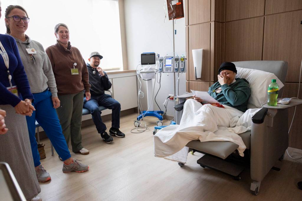 April Lagajeno becomes emotional after receiving a certificate from her nurses while receiving her last treatment at the infusion center at Providence Regional Medical Center Everett on Thursday, July 2, 2026, in Everett, Washington. (Olivia Vanni / The Herald)
