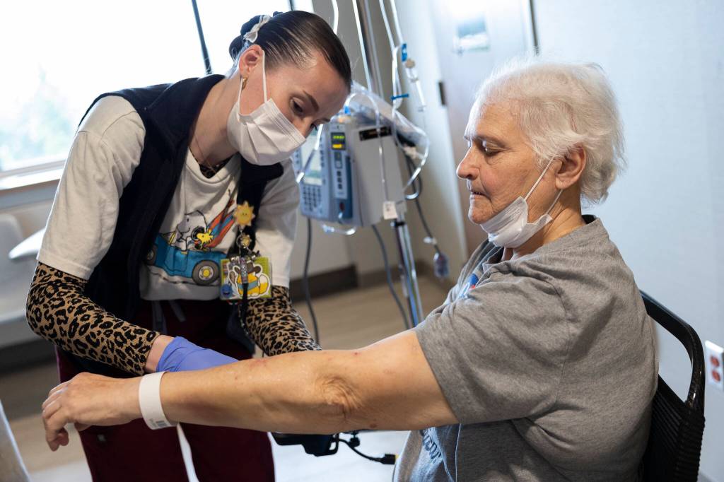 Infusion nurse Leinani Medellin preps patient Debbie Goman before her treatment at the infusion center at Providence Regional Medical Center Everett on Thursday, July 2, 2026, in Everett, Washington. (Olivia Vanni / The Herald)