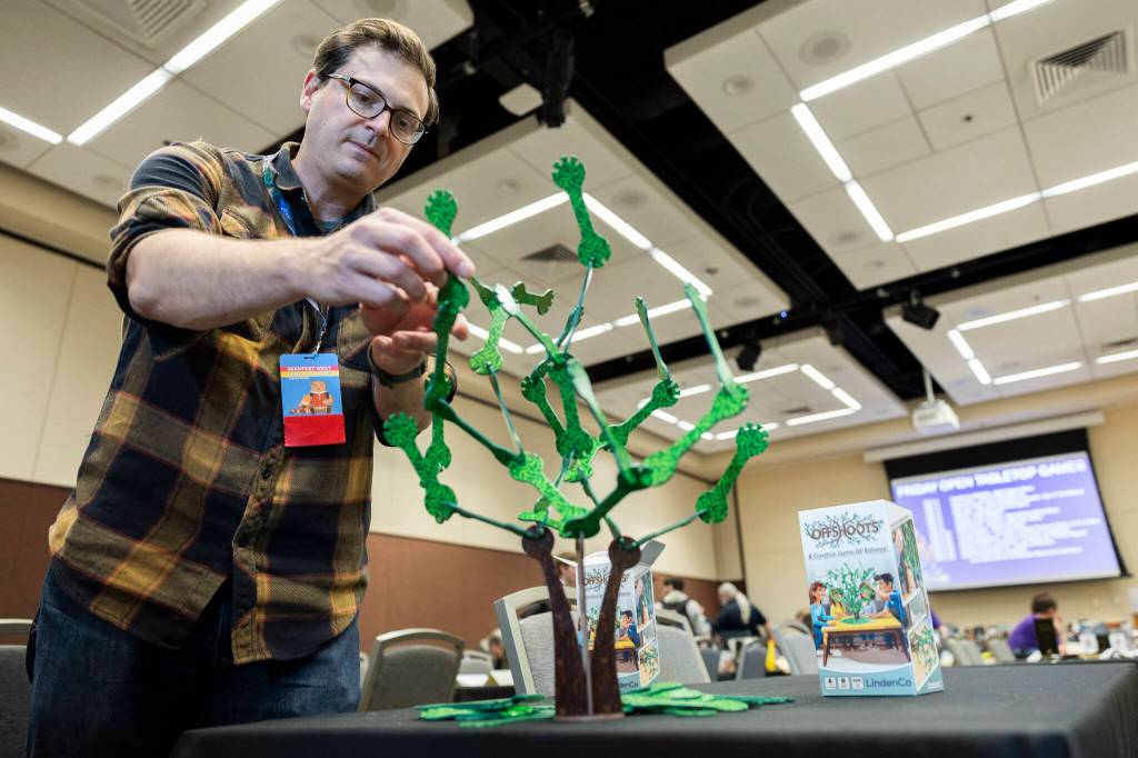 Dan Linden with InDiPro Games sets up Offshoots, a balance game, during GeekFest on Friday, July 17, 2026, in Lynnwood, Washington. (Olivia Vanni / The Herald)