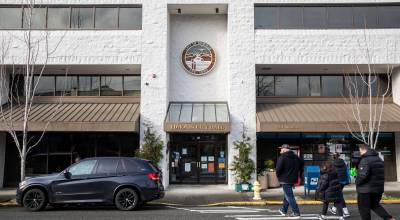 Pedestrians cross the street in front of Edmonds City Hall on Thursday, Dec. 28, 2023 in Edmonds, Washington. (Olivia Vanni / The Herald)
