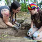 Freyr Buck reacts to a piece of pottery in the hands of Hannah Greengrass found while digging in their roped off section of the dig site at Japanese Gulch on Tuesday, July 28, 2026 in Mukilteo, Washington. (Olivia Vanni / The Herald)
