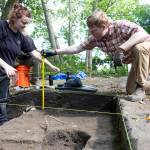 Toby Haaf and Ryan Babjak record measurements of their dig site on Tuesday, July 28, 2026 in Mukilteo, Washington. (Olivia Vanni / The Herald)