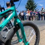 Arlington Rotary Club club member Bill Kmet, who worked with the city for five years on the pump track project, cuts the ribbon at Jensen Park while children wait on their bikes to use the track on Wednesday, July 29, 2026, in Arlington, Washington. (Olivia Vanni / The Herald)