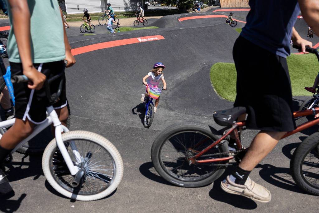 Over 50 bikers and a handful of people on scooters make their way through the Jensen Park pump track on Wednesday, July 29, 2026, in Arlington, Washington. (Olivia Vanni / The Herald)