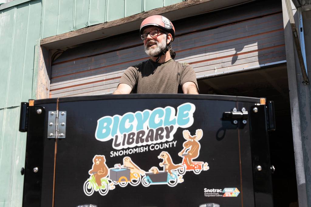 Forrest Baum, the head of the Snohomish County Transportation Coalitions new e-bike library program, poses for a photo while riding a rental e-bike on Tuesday, June 28, 2026, in Everett, Washington. (Will Geschke / The Herald)