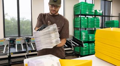Cole Mauch places a stack of sorted ballots into a container in the Snohomish County Election Center on Monday, Aug. 3, 2026 in Everett, Washington. (Olivia Vanni / The Herald)