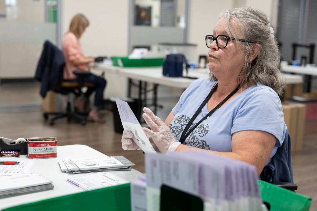 Shauna Willner opens ballots with acceptable signatures to be scanned in the Snohomish County Election Center on Monday, Aug. 3, 2026 in Everett, Washington. (Olivia Vanni / The Herald)