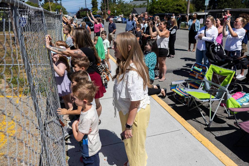 People gather to watch the start of demolition of Jackson Elementary School along Federal Avenue on Thursday, July 30, 2026 in Everett, Washington. (Olivia Vanni / The Herald)